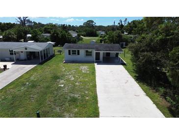 Charming single-story home with a long driveway and well-maintained lawn at 317 E Green St, Englewood, FL 34223