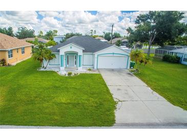 Single-story home with a large green lawn and a two-car garage at 324 Comstock St, Port Charlotte, FL 33954