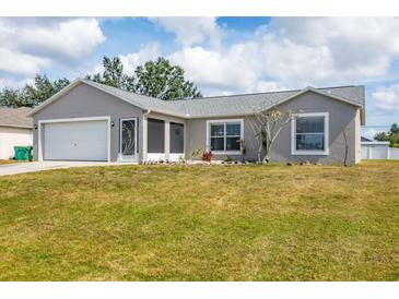 Charming single-story home with a well-manicured lawn and an attached two-car garage at 6344 Hera St, Englewood, FL 34224