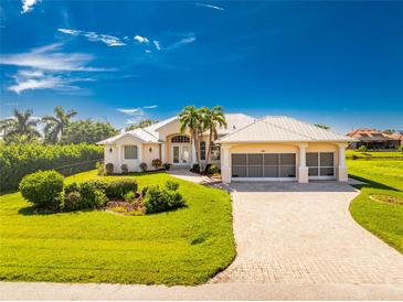 Beautiful one-story home with a tile roof, lush landscaping, and a large driveway at 247 Tournament Rd, Rotonda West, FL 33947