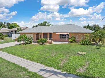 Single-story home with a peach-colored facade and a spacious lawn at 7506 Spinnaker Blvd, Englewood, FL 34224