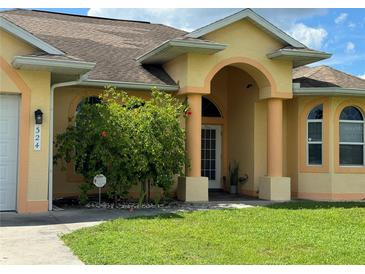 Beautiful two-story home with a manicured lawn and covered entryway at 324 Santurce Ave, North Port, FL 34287