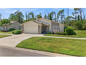 Single-story home with attached garage and well-maintained lawn at 404 Cypress Forest Dr, Englewood, FL 34223