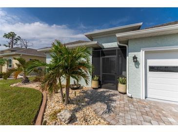 Landscaped front yard with palm trees and brick pavers at 552 Box Elder Ct, Englewood, FL 34223