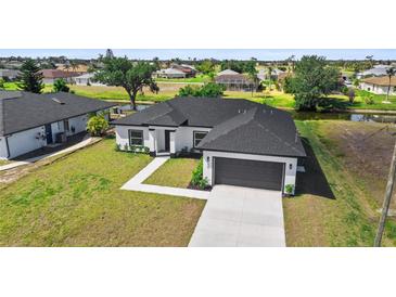 A charming single-Gathering home with a two-car garage and a well-manicured lawn near the canal at 220 Mark Twain Ln, Rotonda West, FL 33947