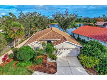 Single-story home with lake view and mature landscaping at 3195 Village Ln, Port Charlotte, FL 33953