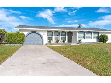 Charming single story home with grey garage door and manicured lawn at 20 Annapolis Ln, Rotonda West, FL 33947