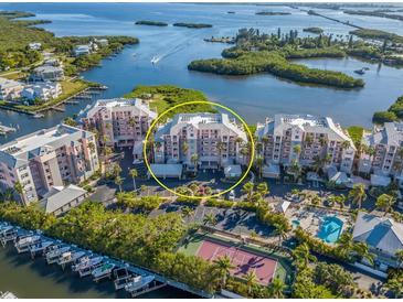 Aerial view of waterfront community with tennis court and pool at 13313 Gasparilla Rd # C205, Placida, FL 33946