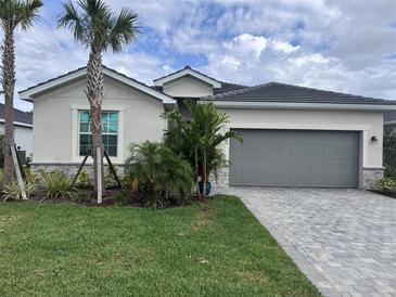 Inviting single-Gathering home showcasing lush landscaping and a well-maintained two car garage at 19060 Moscato Ct, Venice, FL 34293