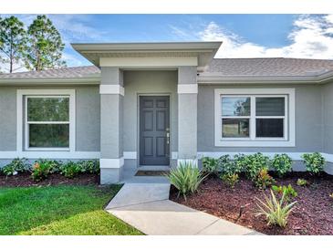 Gray house with dark gray door and landscaping at 2775 Wyola Ave, North Port, FL 34286