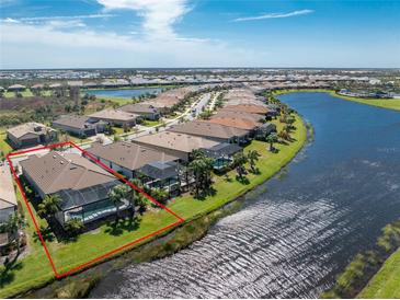Aerial view of home with pool and canal views at 13077 Rinella St, Venice, FL 34293