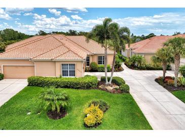Single-story home with tile roof, two-car garage, and lush landscaping at 2844 Myakka Creek Ct, Port Charlotte, FL 33953