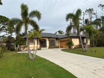 One-story home with attached garage and palm trees at 5160 Farewell St, Port Charlotte, FL 33981