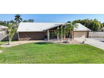 Single-story home with metal roof, stone accents, and landscaped yard at 12325 Mitchell Ter, Port Charlotte, FL 33981