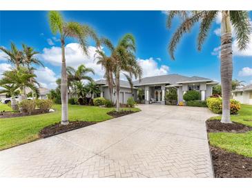 Single Gathering home with a large driveway, lush landscaping, and palm trees at 848 Boundary Blvd, Rotonda West, FL 33947