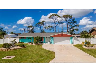 Charming ranch home with teal exterior and landscaped yard at 1132 Piedmont Rd, Venice, FL 34293