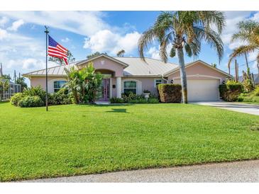 Single-story home with metal roof, lush lawn, and mature landscaping at 3 Pinehurst Ct, Rotonda West, FL 33947