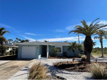 Charming light blue single story home with a white garage door and landscaped yard at 9 Annapolis Ln, Rotonda West, FL 33947