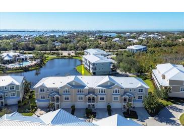 Aerial view of waterfront townhouses with a community pool and lush landscaping at 10325 Longshore Rd # 20, Placida, FL 33946