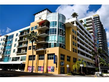 Modern urban condo building with yellow facade and parking garage at 1120 E Kennedy Blvd # 1423, Tampa, FL 33602