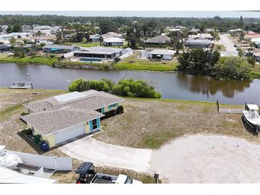 Waterfront home with a boat and canal access in a quiet neighborhood with palm trees at 42 Caroll Cir, Englewood, FL 34223