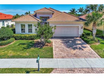 Single-story home with tile roof, landscaping, and a paved driveway at 12960 N Marsh Dr, Port Charlotte, FL 33953