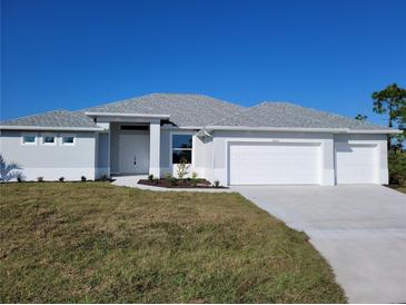 Single-story home with a two-car garage and a well-manicured lawn at 14331 Montmarte Ave, Port Charlotte, FL 33981