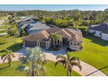 Beautiful home featuring mature landscaping, circular driveway, and a three-car garage at 2 Marker Rd, Rotonda West, FL 33947