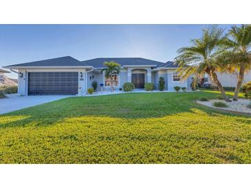 Single-story home with a two-car garage and well-manicured lawn at 213 White Marsh Ln, Rotonda West, FL 33947