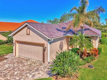 Tan one-story house with tile roof, two-car garage, and landscaped yard at 3179 Osprey Ln, Port Charlotte, FL 33953