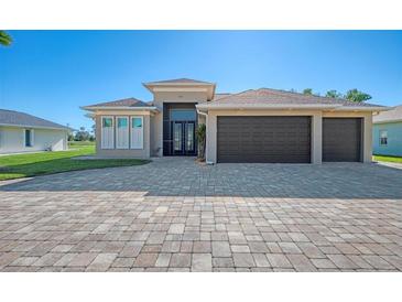 Two-story house with a three-car garage and a paver driveway at 634 Boundary Blvd, Rotonda West, FL 33947