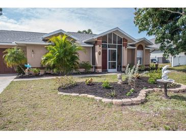 Well-maintained house with attractive landscaping and a screened porch at 97 Mariner Ln, Rotonda West, FL 33947