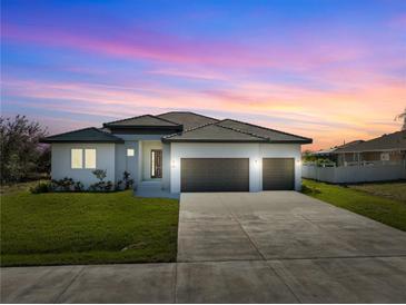 Single-story home with three-car garage, landscaping, and a neutral color palette at 14681 Keystone Blvd, Port Charlotte, FL 33981