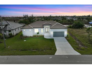 Aerial view of a single-story home with a two-car garage and landscaped lawn at 15384 Hennipen Cir, Port Charlotte, FL 33981