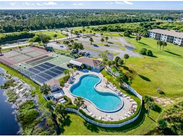 Community pool, tennis courts, and clubhouse with lush landscaping at 175 Kings Hwy # 234, Punta Gorda, FL 33983