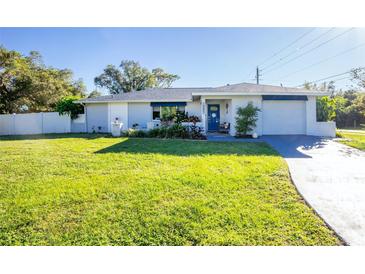 Charming single story home with a well-manicured lawn and updated facade at 18497 Kuldin Ave, Port Charlotte, FL 33948