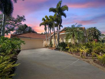 Single-story home with tile roof, palm trees, and a long driveway at 3117 Silkwood Ln, Port Charlotte, FL 33953