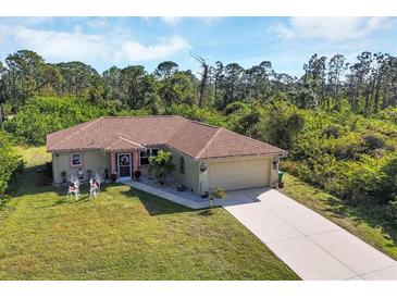 Single-story home with a large yard, driveway, and festive decorations at 4036 Elvington Rd, Port Charlotte, FL 33981