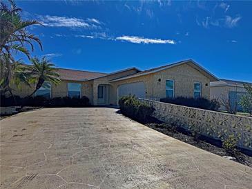 Single-story home with a large driveway and landscaped front yard at 89 Caddy Rd, Rotonda West, FL 33947