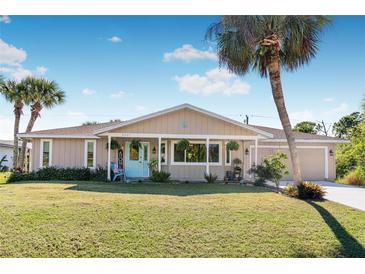 Charming single-story home with a covered porch and landscaped lawn at 9487 Prospect Ave, Englewood, FL 34224