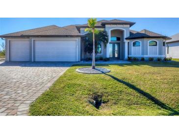 Two-story home with three car garage and manicured lawn at 15336 Lakeland Cir, Port Charlotte, FL 33981