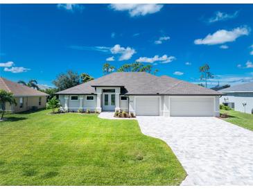 Attractive single-story home with a three-car garage and landscaped lawn at 35 Broadmoor Ln, Rotonda West, FL 33947