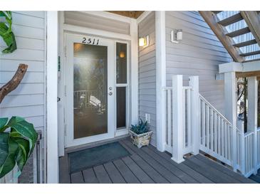 Inviting condo entry with glass door, light gray siding, and small deck at 7482 Palm Island Dr # 2511, Placida, FL 33946