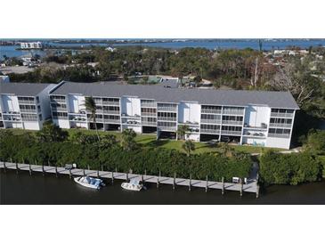 Aerial view of a waterfront condo building with private boat docks at 1401 S Mccall Rd # 306B, Englewood, FL 34223