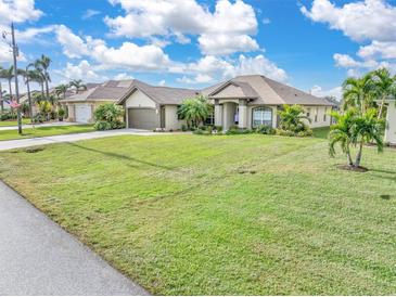 Single-story home with attached two-car garage and large lawn at 171 Medalist Rd, Rotonda West, FL 33947