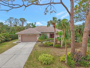 Single-story home with landscaped yard, driveway, and two-car garage at 1741 Fessler St, Englewood, FL 34223