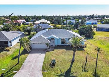 Charming blue home with landscaped yard and attached two-car garage at 9131 Berendo Ave, Englewood, FL 34224