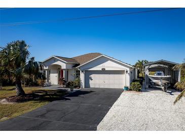 Charming Florida home with attached garage, carport, and lush landscaping at 9300 Miami Cir, Port Charlotte, FL 33981