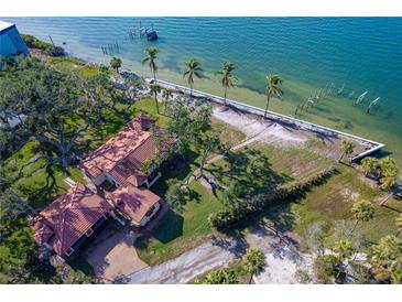 Aerial view of waterfront home with expansive lot and mature trees at 99 W Riverview Ave, Englewood, FL 34223