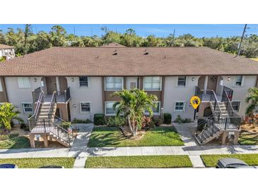 Aerial view of a condo building with two stories, brown roofs, and staircases leading to each unit at 25100 Sandhill Blvd # B-103, Punta Gorda, FL 33983